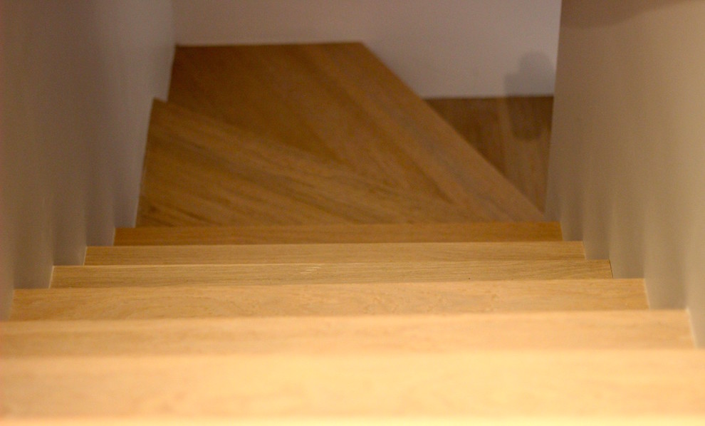 Ejemplo de escalera en L contemporánea pequeña con escalones de madera y contrahuellas de madera