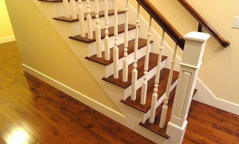 На фото: угловая деревянная лестница среднего размера в классическом стиле с деревянными ступенями и деревянными перилами