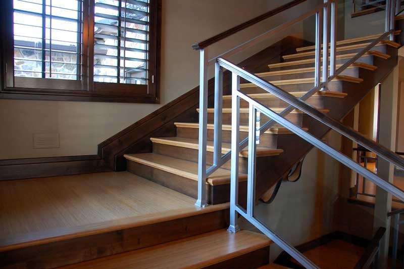 Diseño de escalera en L clásica renovada con escalones de madera, contrahuellas de madera y barandilla de vidrio