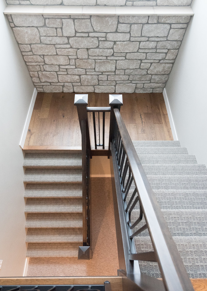 Réalisation d'un grand escalier chalet en U avec des marches en moquette, des contremarches en bois et un garde-corps en matériaux mixtes.