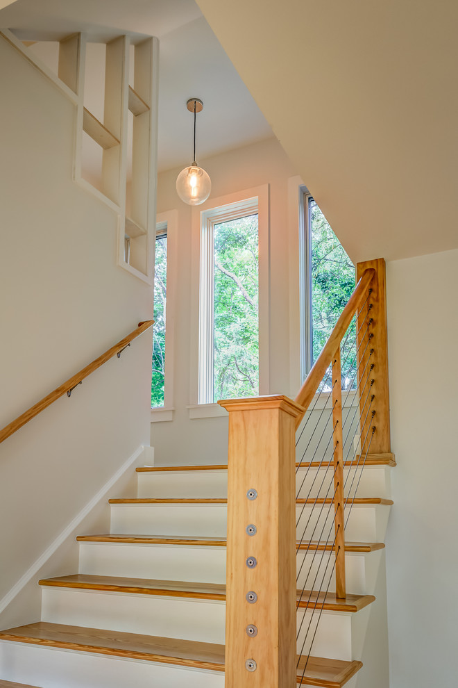 Foto de escalera en U actual pequeña con escalones de madera y contrahuellas de madera pintada
