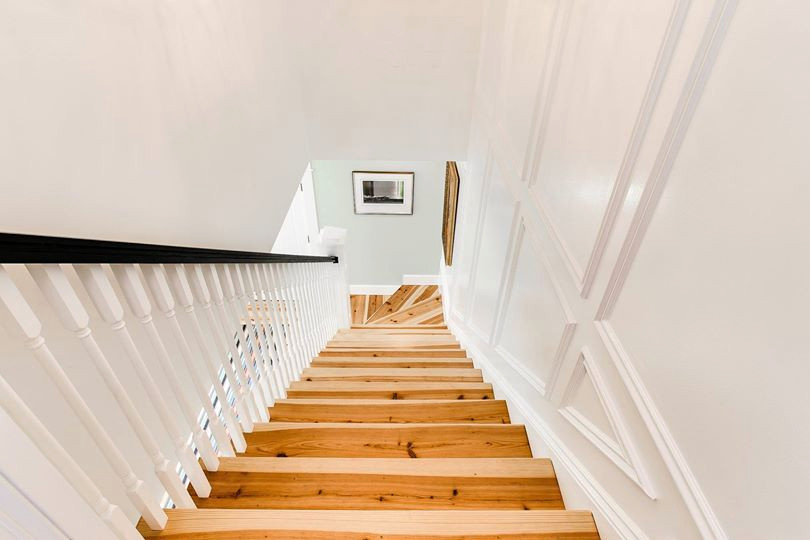 Ejemplo de escalera en L rústica de tamaño medio con escalones de madera, contrahuellas de madera y barandilla de madera