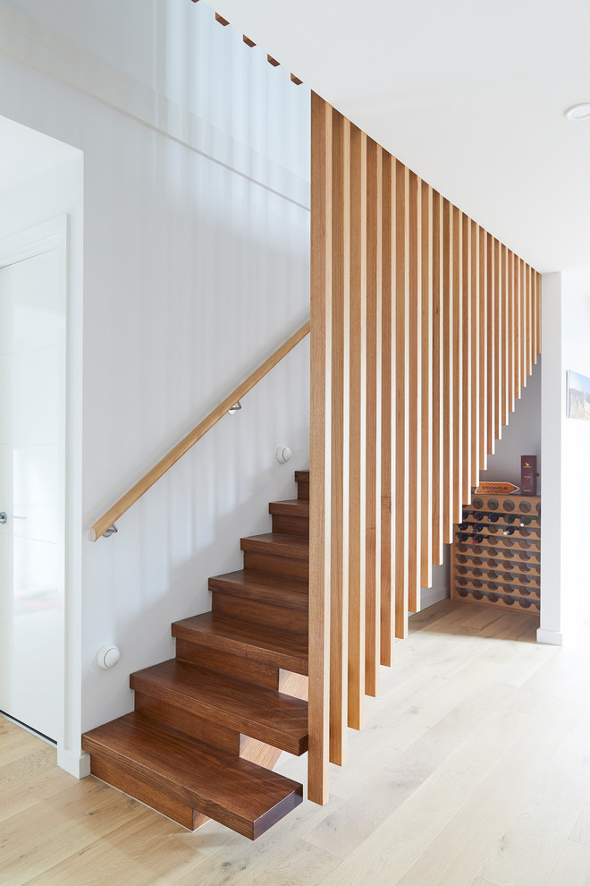 Idee per una scala a rampa dritta minimalista di medie dimensioni con pedata in legno, alzata in legno e parapetto in legno