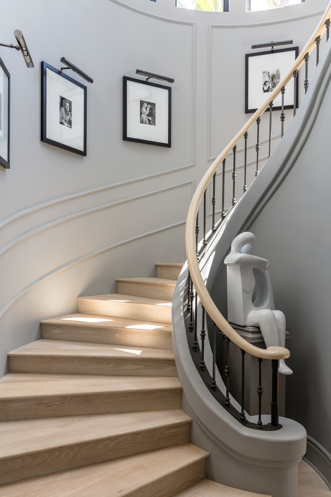 Design ideas for a classic wood curved mixed railing staircase in Los Angeles with wood risers.
