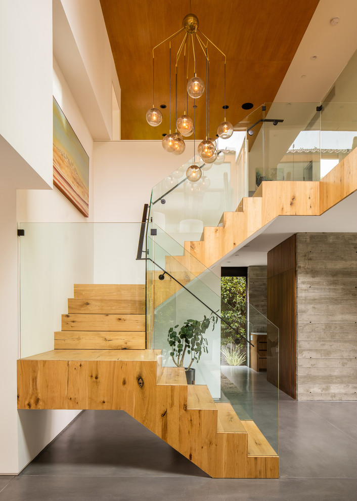 Idées déco pour un escalier contemporain en U avec des marches en bois, des contremarches en bois, un garde-corps en métal et éclairage.