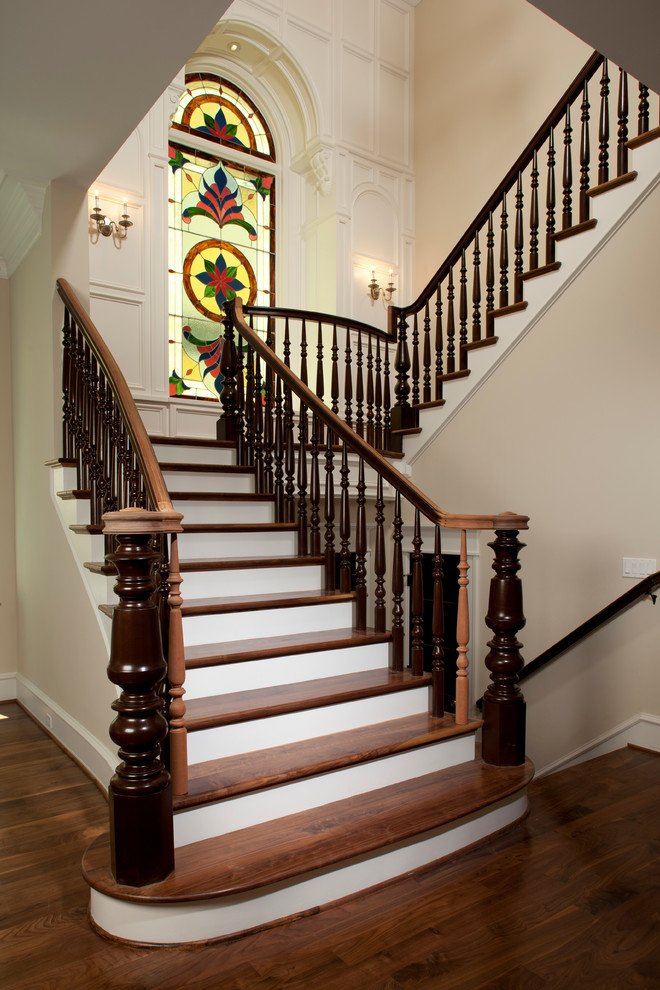 На фото: п-образная лестница в викторианском стиле с деревянными ступенями и крашенными деревянными подступенками с