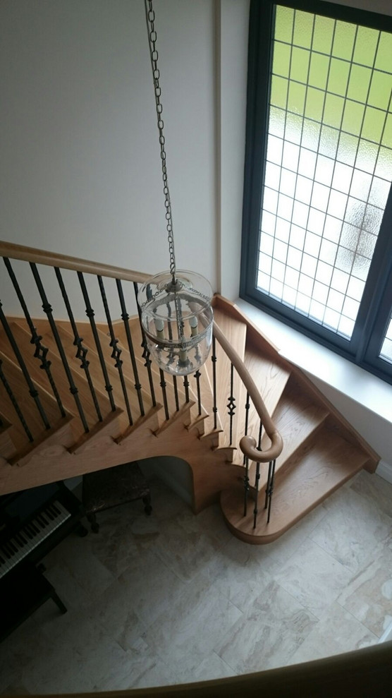 Gewendelte, Mittelgroße Klassische Holztreppe mit Holz-Setzstufen und Stahlgeländer in Cheshire