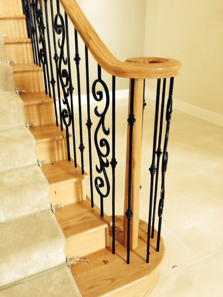Staircase - large cottage wooden curved metal railing staircase idea in Other with wooden risers
