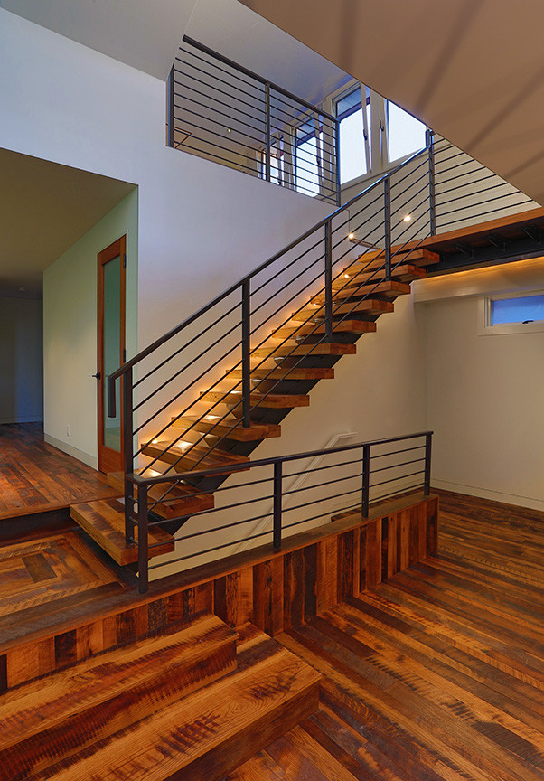 Cette image montre un grand escalier sans contremarche flottant design avec des marches en bois.