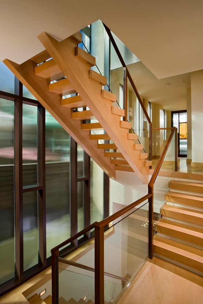 This is an example of a large contemporary wood u-shaped staircase in Los Angeles with open risers.