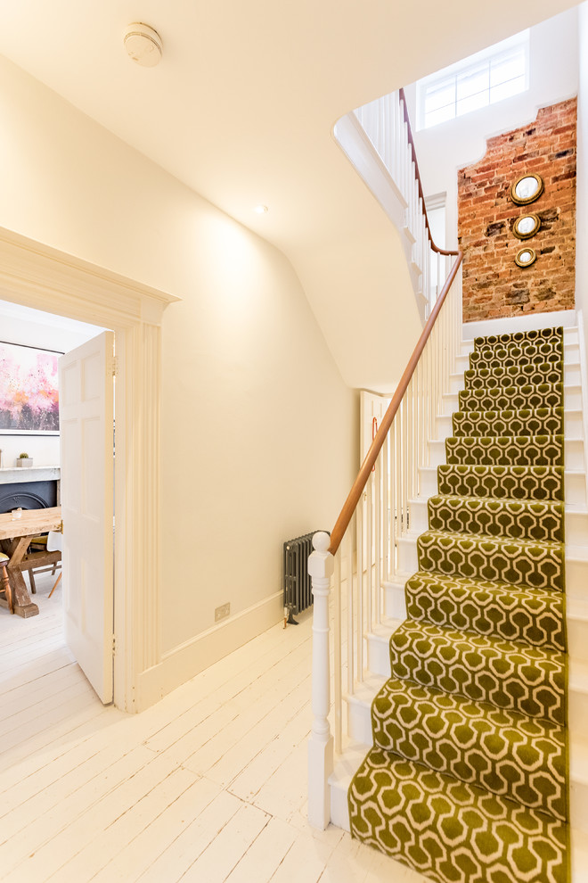 Mid-sized eclectic carpeted wood railing staircase photo in London with carpeted risers