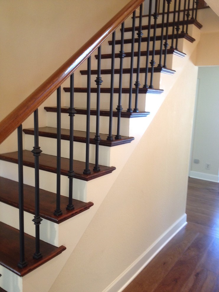 Diseño de escalera recta tradicional de tamaño medio con barandilla de madera, escalones de madera y contrahuellas de madera pintada