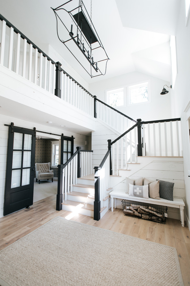Ejemplo de escalera en L de estilo de casa de campo de tamaño medio con escalones de madera, contrahuellas de madera y barandilla de madera