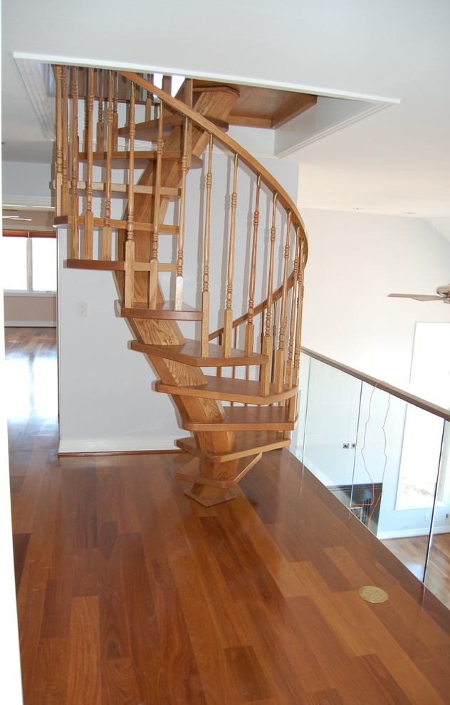 Modelo de escalera de caracol actual de tamaño medio sin contrahuella con escalones de madera y barandilla de madera