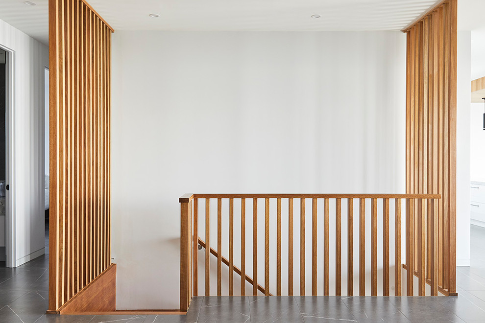 Inspiration pour un escalier minimaliste en L de taille moyenne avec des marches en bois, des contremarches en bois et un garde-corps en bois.