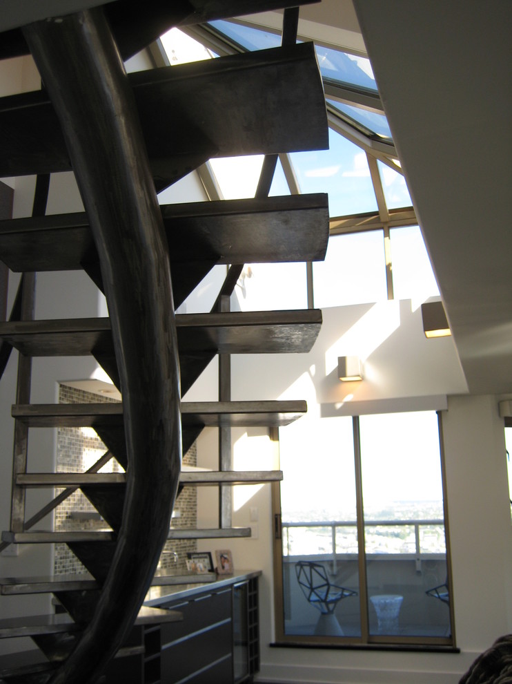 Imagen de escalera curva actual grande sin contrahuella con escalones de metal