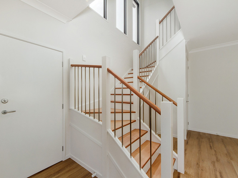 Diseño de escalera curva contemporánea de tamaño medio con escalones de madera y barandilla de madera