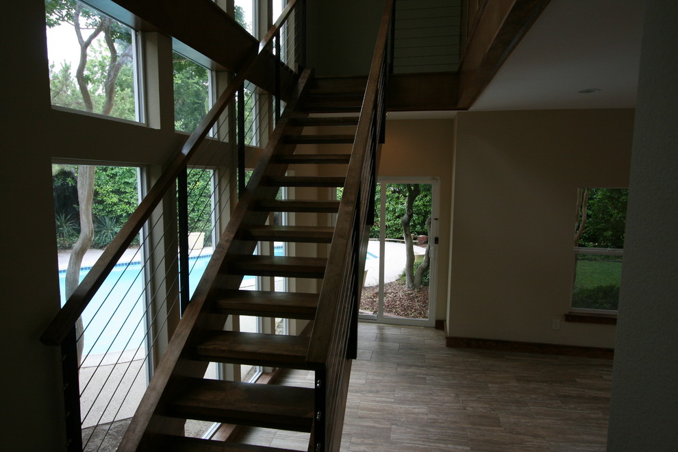 Diseño de escalera suspendida actual grande sin contrahuella con escalones de madera