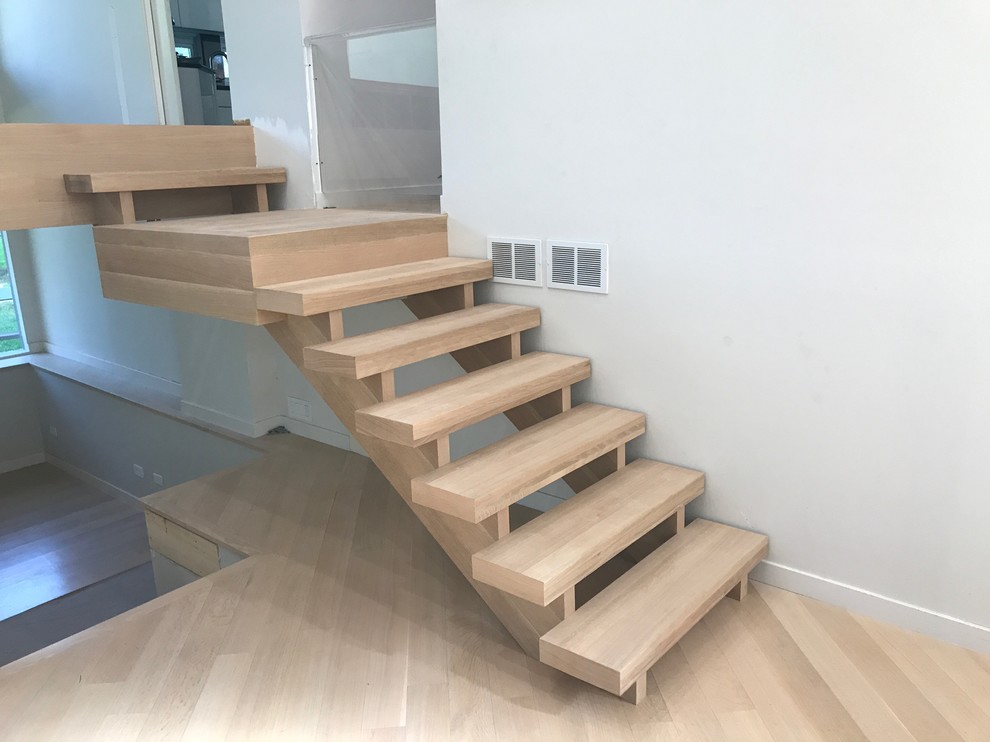 Design ideas for a small contemporary wood straight glass railing staircase in Chicago with open risers.