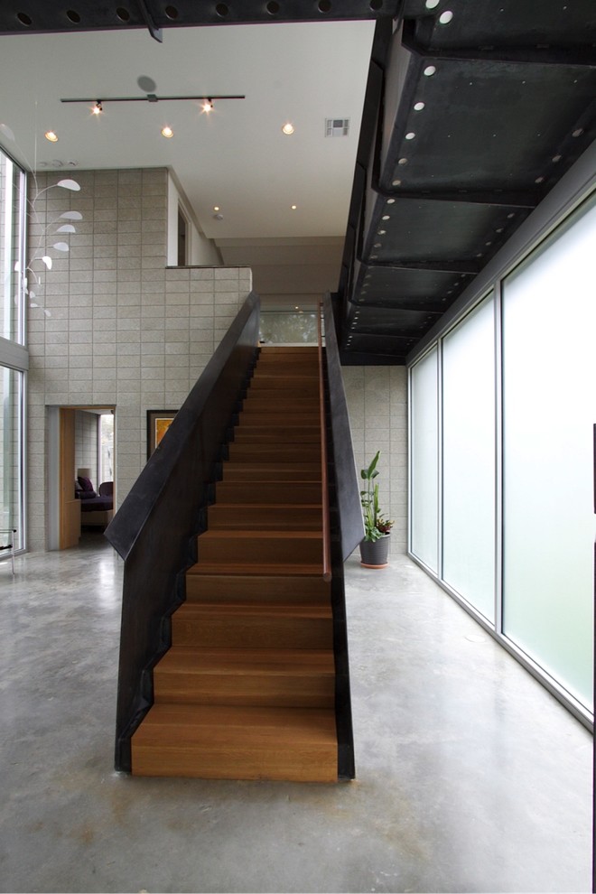 This is an example of a contemporary wood straight staircase in Houston with wood risers.