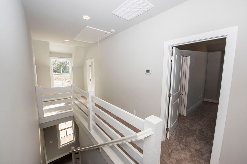 Ejemplo de escalera recta de estilo de casa de campo de tamaño medio con barandilla de madera