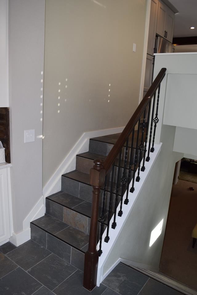 Aménagement d'un petit escalier carrelé classique en L avec des contremarches carrelées et un garde-corps en bois.