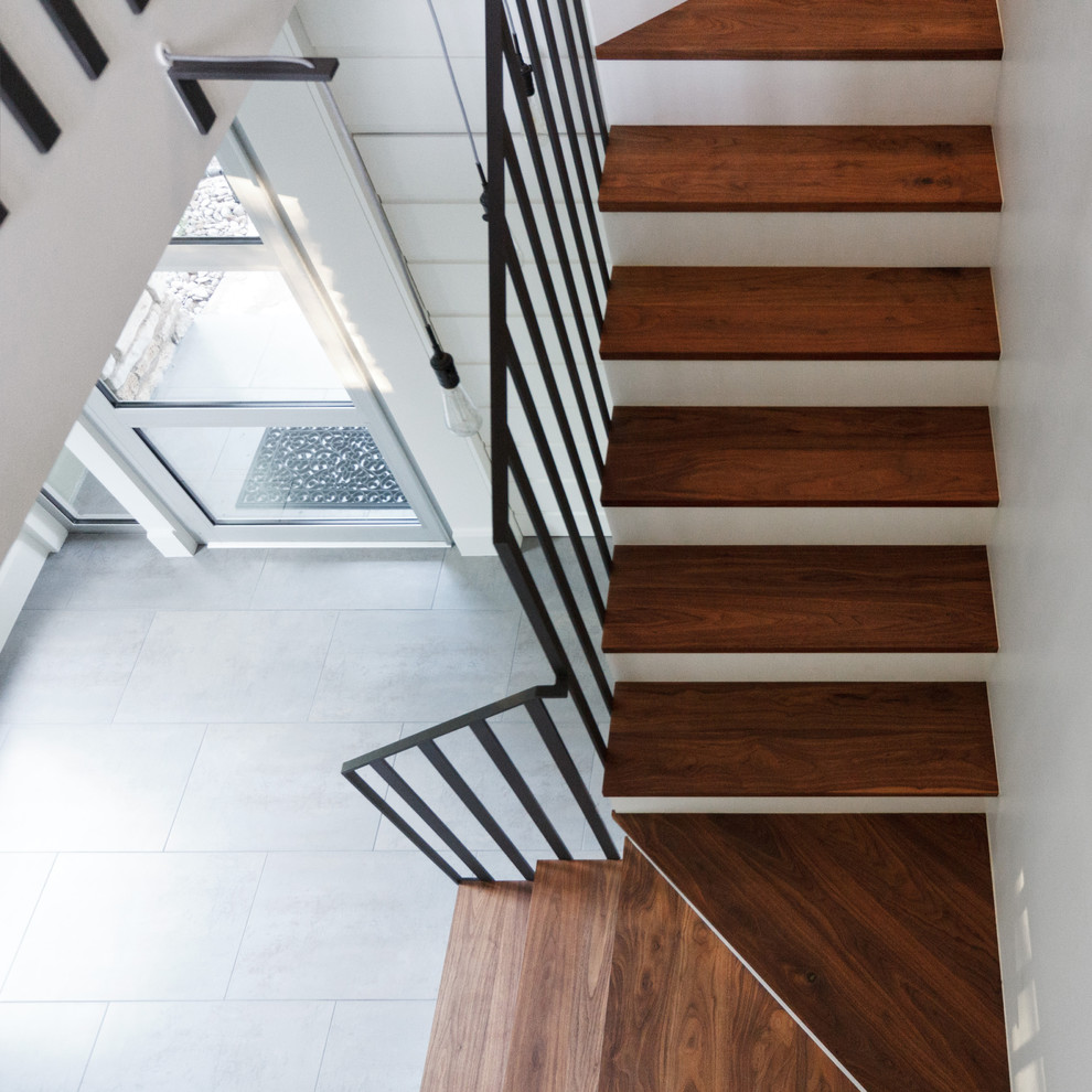 Пример оригинального дизайна: п-образная лестница в стиле неоклассика (современная классика) с деревянными ступенями и крашенными деревянными подступенками