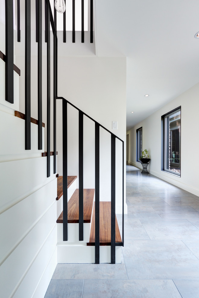 Стильный дизайн: п-образная лестница в стиле неоклассика (современная классика) с деревянными ступенями и крашенными деревянными подступенками - последний тренд