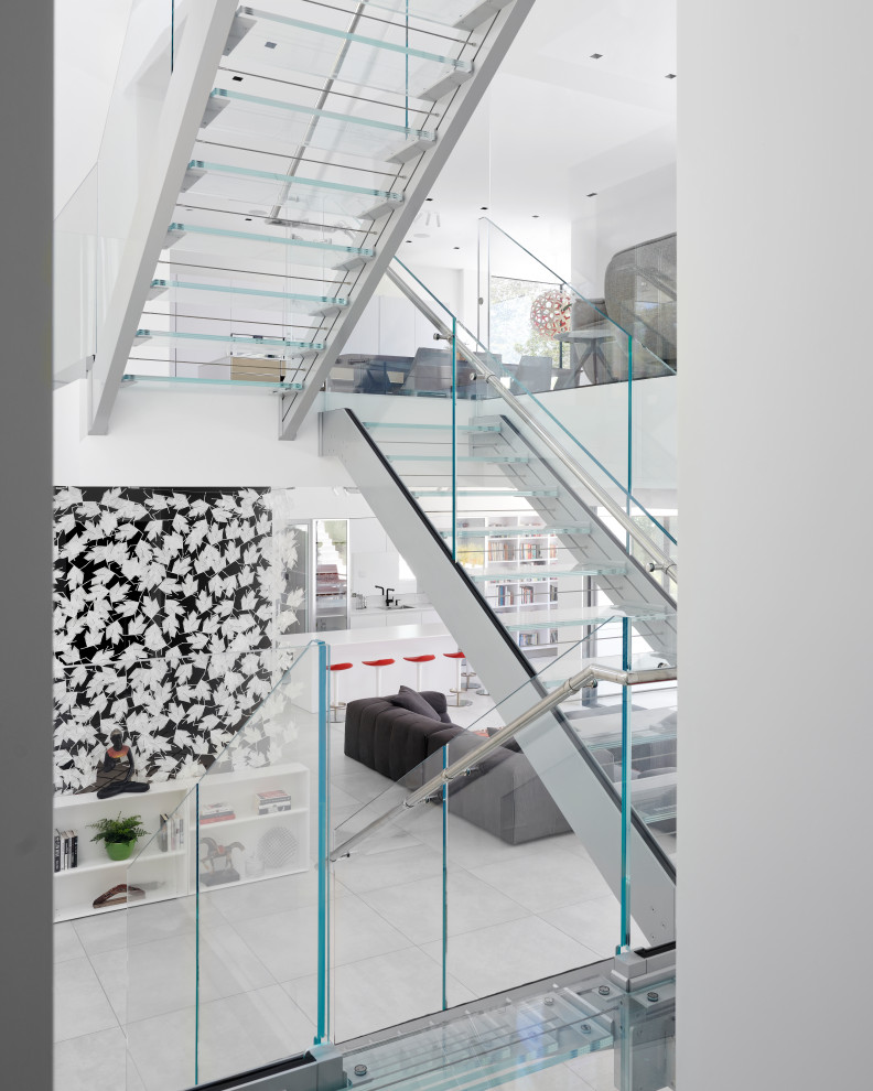 Идея дизайна: большая лестница на больцах в современном стиле с стеклянными ступенями, стеклянными подступенками и стеклянными перилами