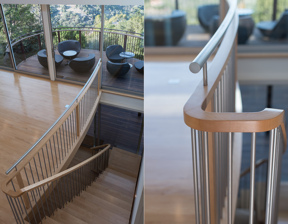 Inspiration pour un grand escalier sans contremarche courbe design avec des marches en bois.
