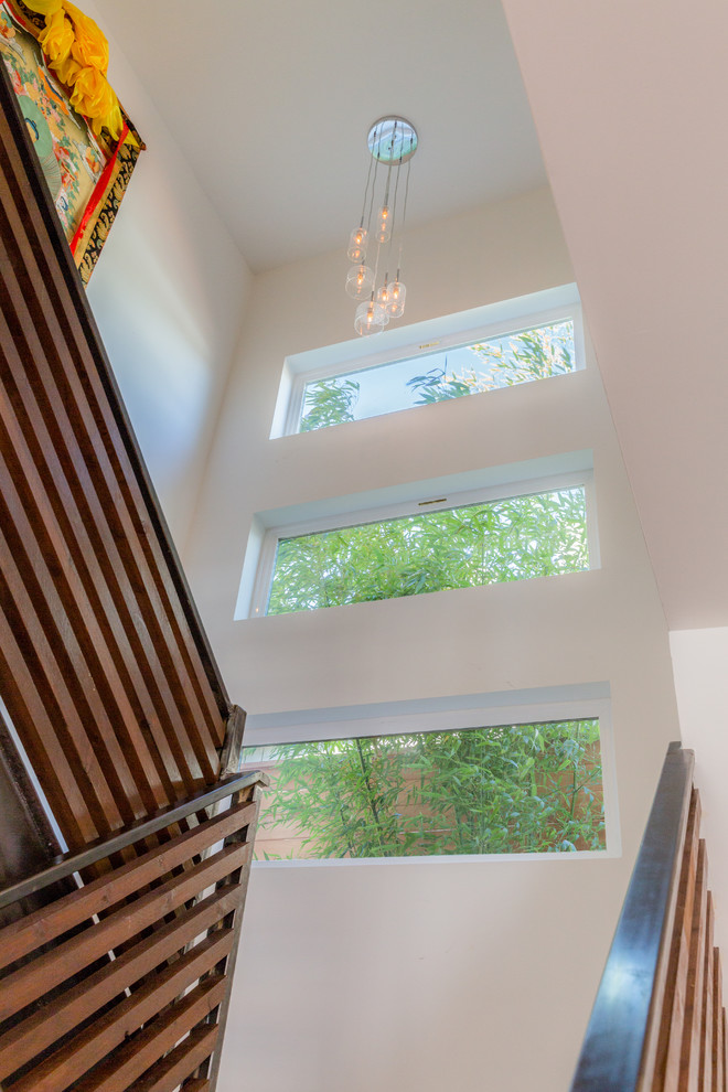 Пример оригинального дизайна: п-образная лестница среднего размера в современном стиле с деревянными ступенями и перилами из смешанных материалов без подступенок