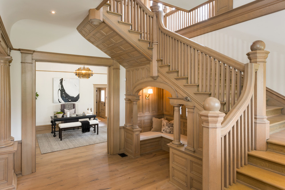 Ejemplo de escalera en U clásica con escalones de madera, contrahuellas de madera y barandilla de madera