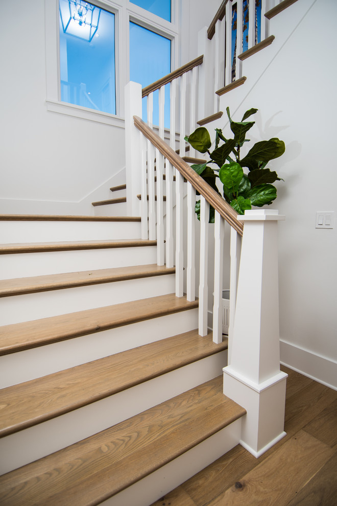 Exemple d'un grand escalier courbe nature avec des marches en bois, des contremarches en bois et un garde-corps en bois.