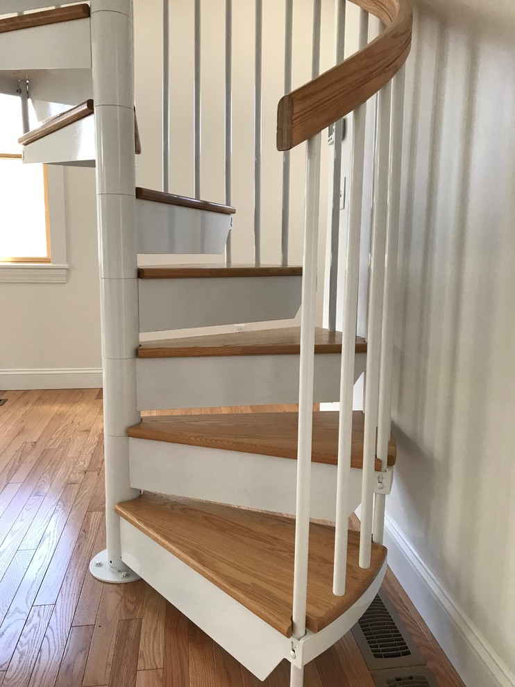 На фото: винтовая лестница среднего размера в классическом стиле с деревянными перилами без подступенок с