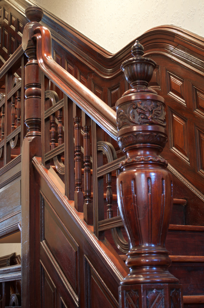 Foto de escalera tradicional con escalones de madera, contrahuellas de madera y barandilla de madera