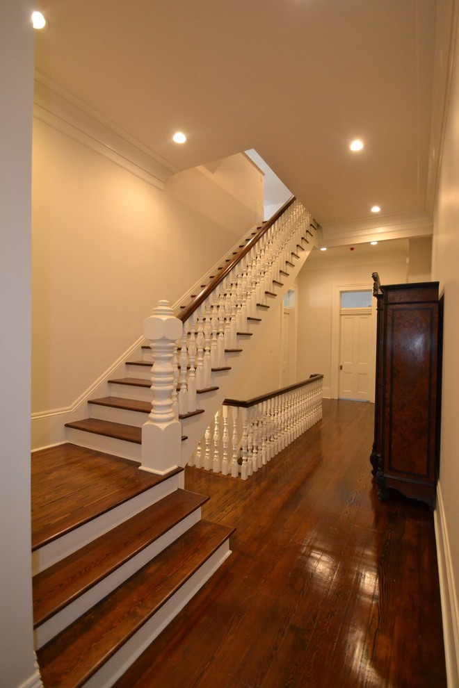 Cette photo montre un grand escalier peint droit chic avec des marches en bois et un garde-corps en bois.