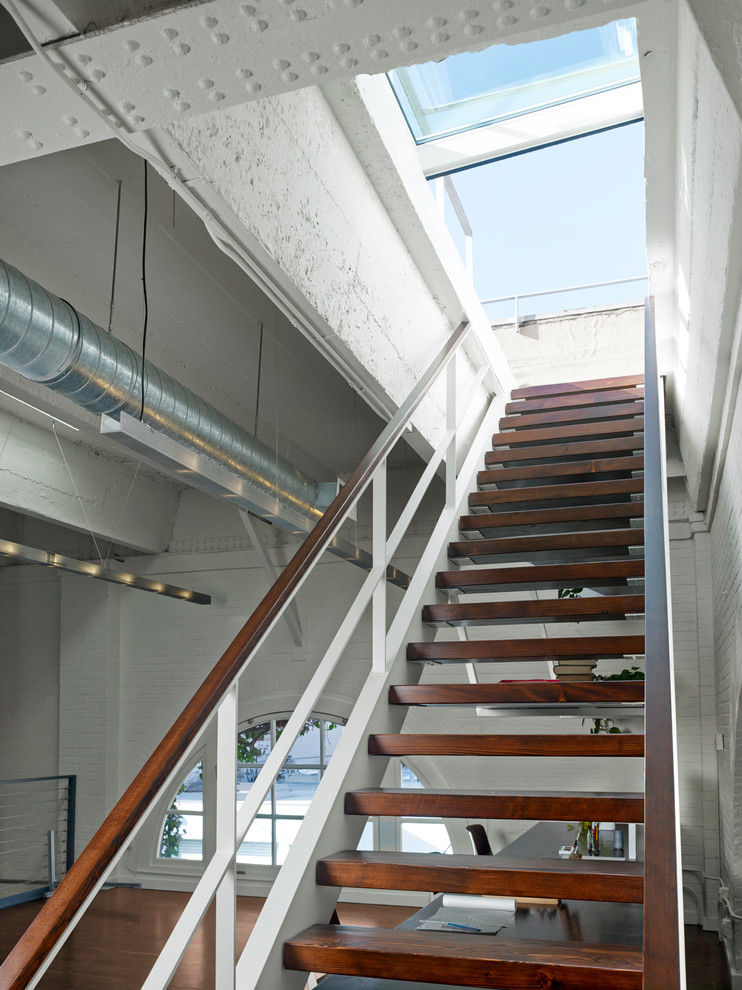На фото: большая прямая лестница в стиле лофт с деревянными ступенями без подступенок с