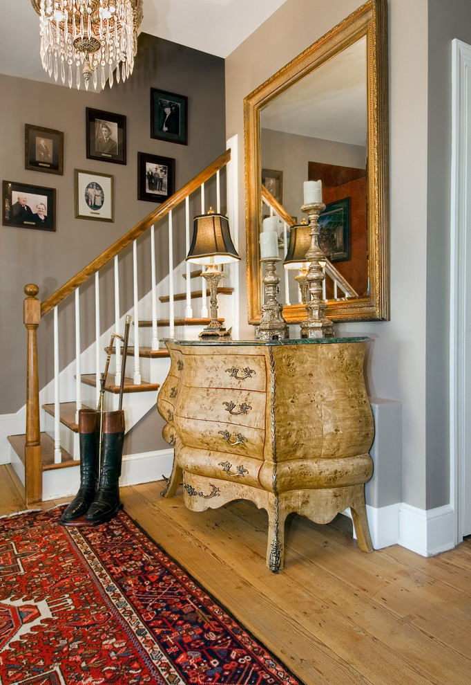 Imagen de escalera clásica de tamaño medio con escalones de madera, contrahuellas de madera pintada y barandilla de madera