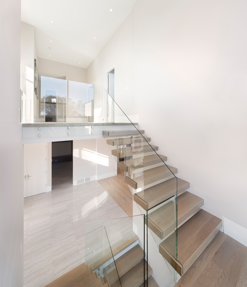 Modelo de escalera suspendida minimalista grande con escalones de madera, contrahuellas de madera y barandilla de vidrio