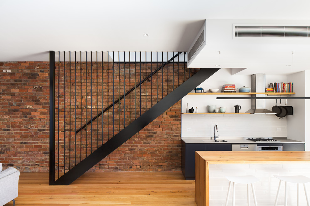 На фото: прямая лестница среднего размера в стиле лофт с деревянными ступенями и металлическими перилами без подступенок с