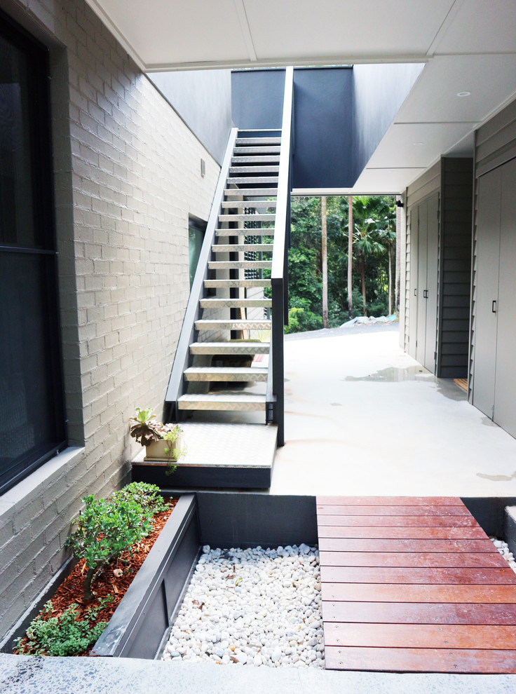 На фото: прямая металлическая лестница среднего размера в стиле модернизм с металлическими ступенями и металлическими перилами