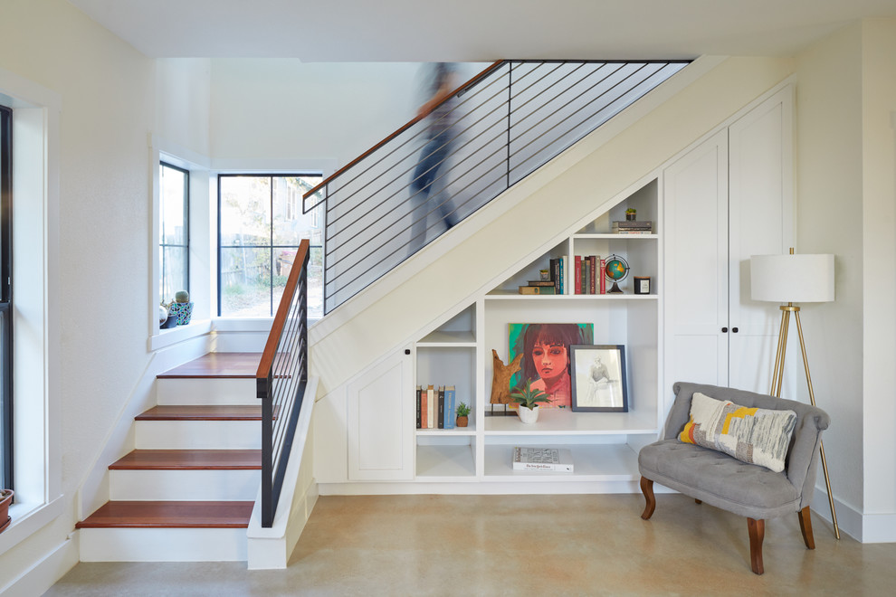 Cette photo montre un petit escalier peint tendance en L avec des marches en bois, un garde-corps en métal, rangements et éclairage.