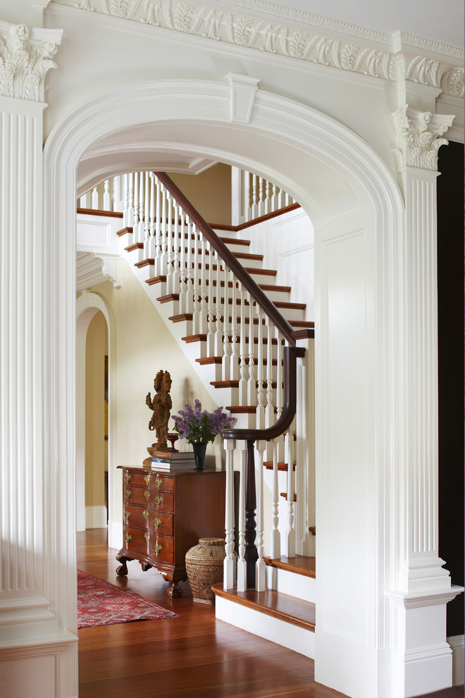 Idées déco pour un très grand escalier classique en L avec des marches en bois, des contremarches en bois et un garde-corps en bois.