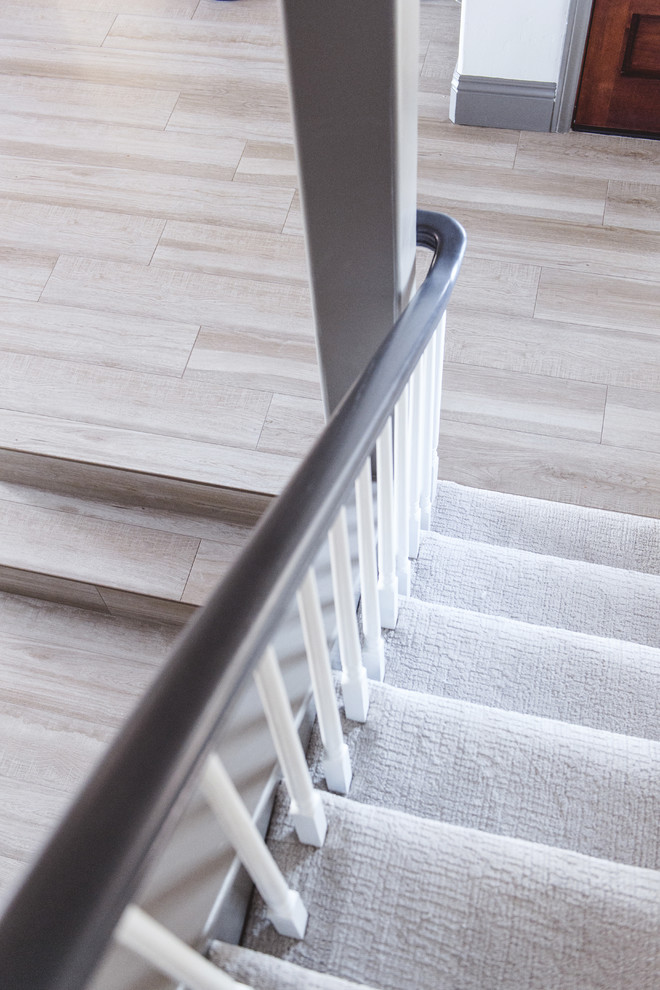 Imagen de escalera en L actual de tamaño medio con escalones enmoquetados, contrahuellas enmoquetadas y barandilla de madera