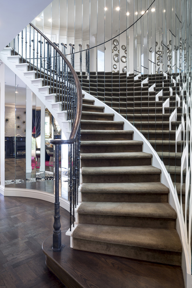 Стильный дизайн: большая изогнутая лестница в современном стиле с перилами из смешанных материалов, крашенными деревянными ступенями и крашенными деревянными подступенками - последний тренд