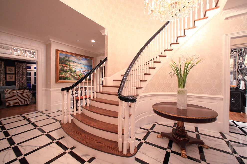 Large classic wood curved staircase in Raleigh with painted wood risers.