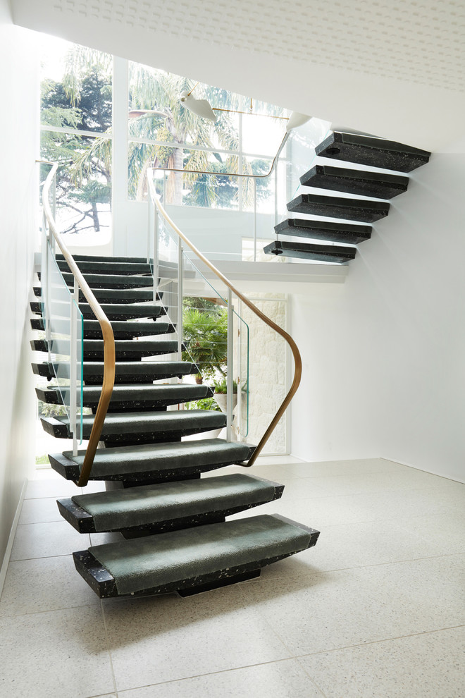 Inspiration för moderna svängda trappor, med öppna sättsteg och räcke i flera material