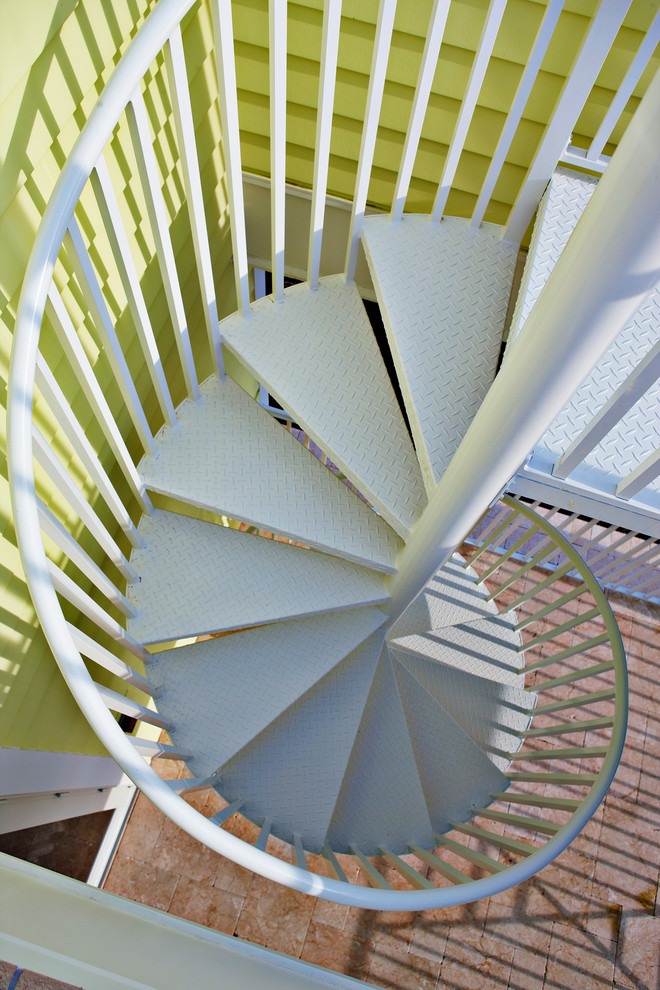 На фото: маленькая винтовая лестница в современном стиле с металлическими ступенями и металлическими перилами без подступенок для на участке и в саду