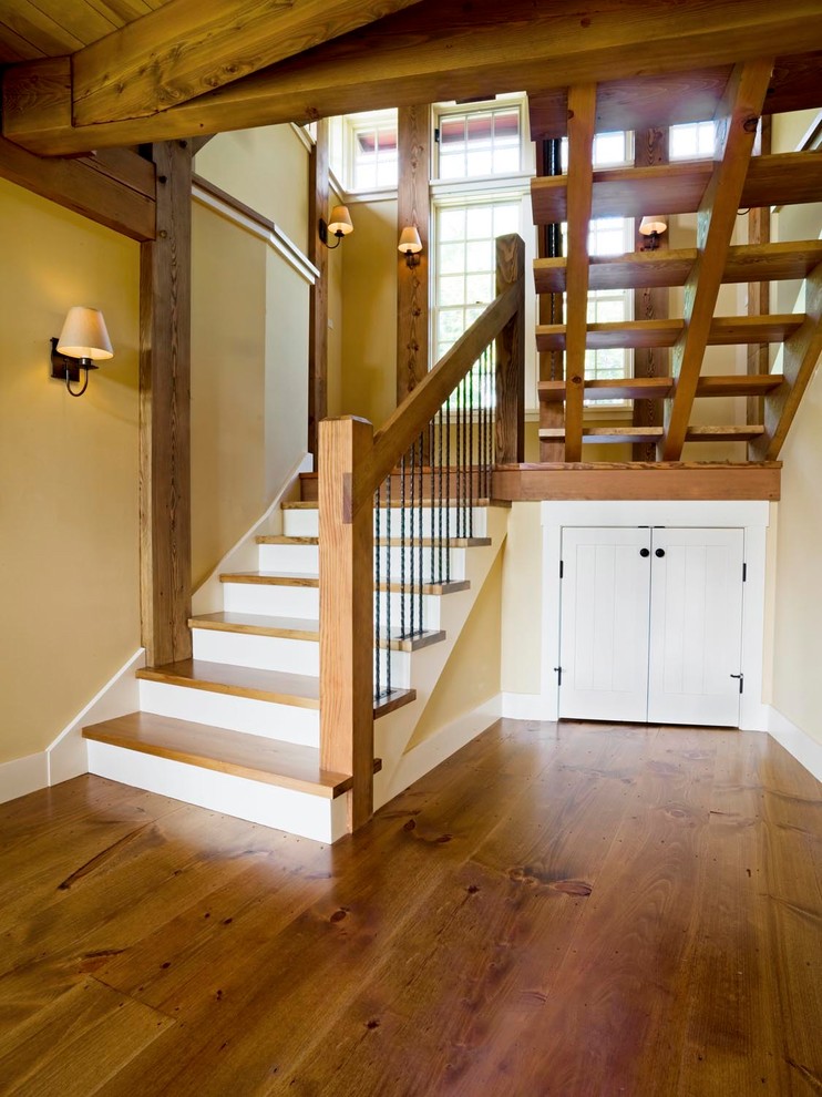Foto de escalera en U rústica grande sin contrahuella con escalones de madera y barandilla de madera
