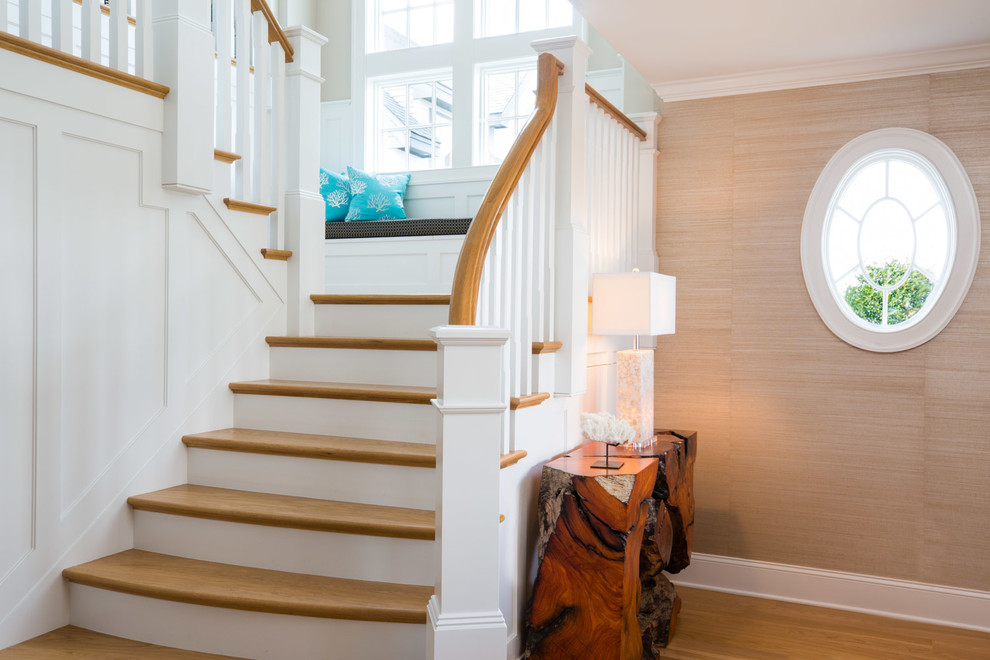 Стильный дизайн: п-образная лестница в морском стиле с деревянными ступенями, крашенными деревянными подступенками и деревянными перилами - последний тренд